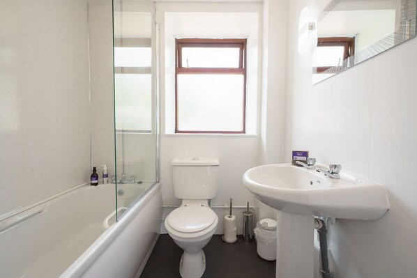 Un baño con bañera, inodoro y lavabo.