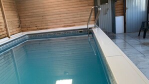 A swimming pool with a wooden deck and a metal ladder. - Jane Welsh Cottage - a cottage that sleeps 4 guests  in 2 bedrooms (Thornhill)