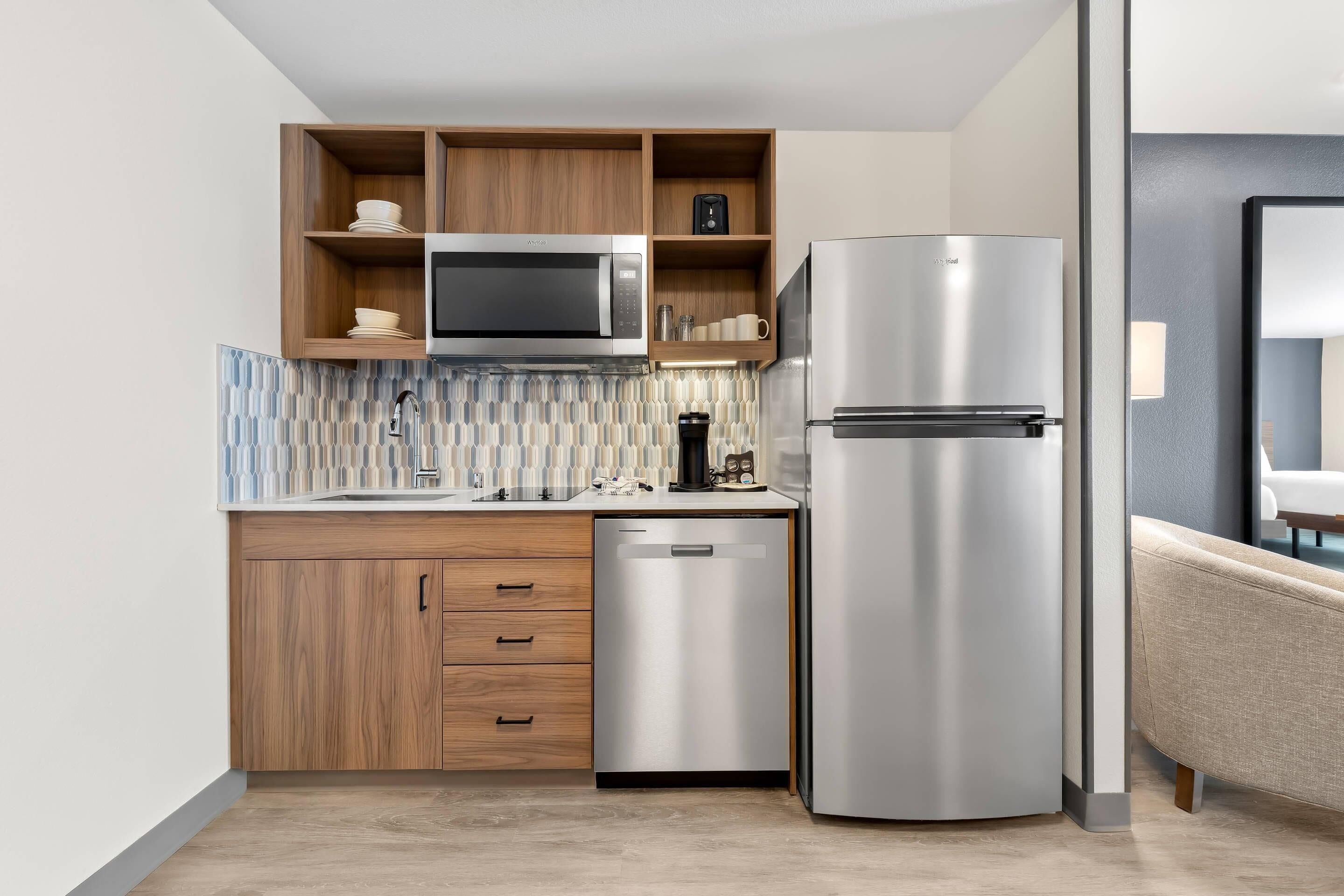 A compact kitchen with a microwave, refrigerator, and dishwasher.