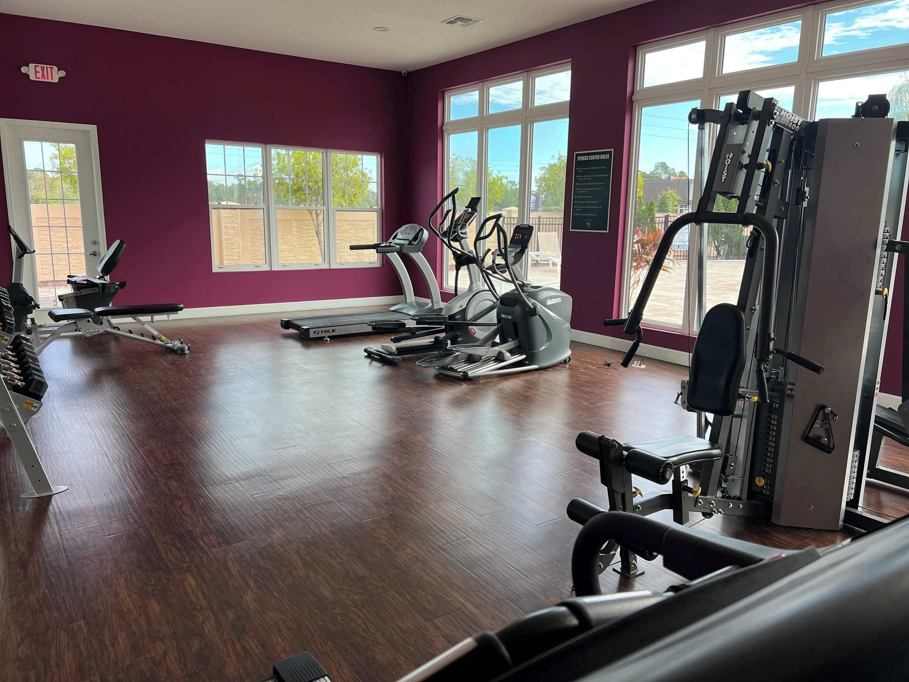 A gym with treadmills, elliptical machines, and weight equipment.