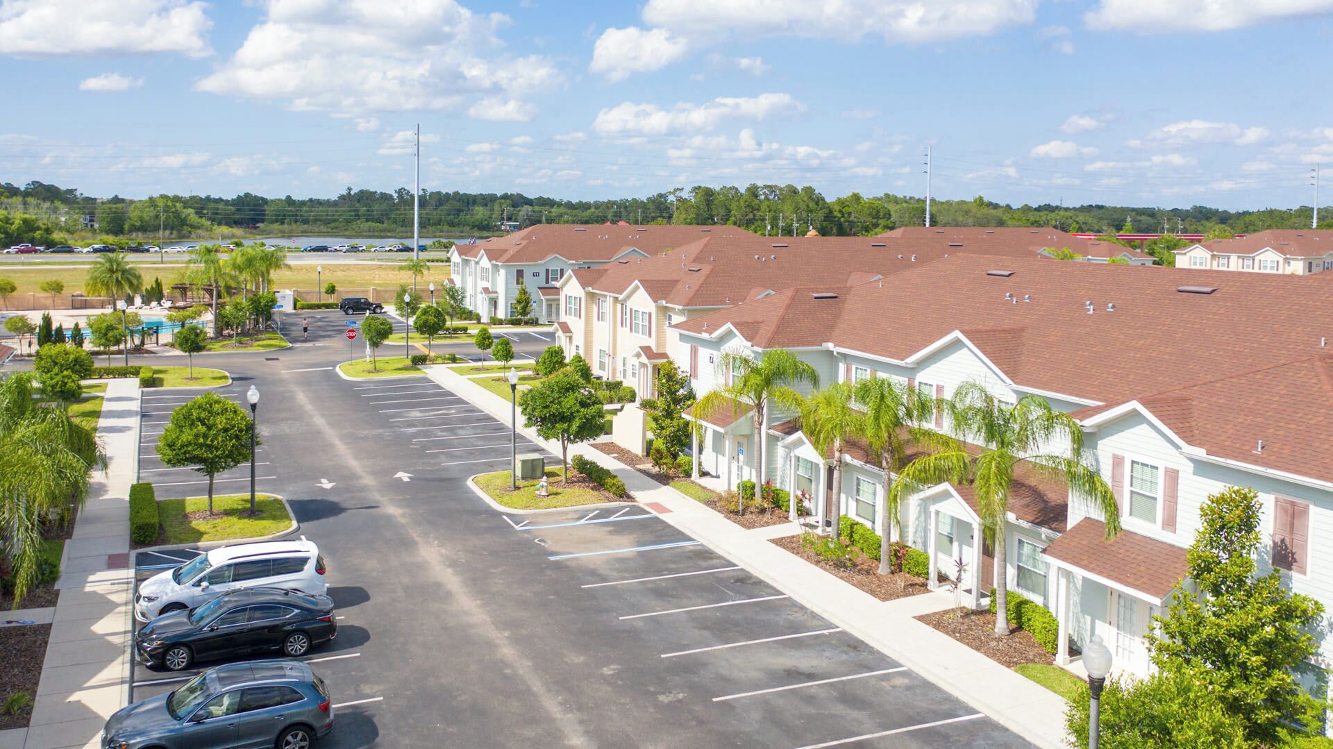A row of single-story houses with a parking lot in front.