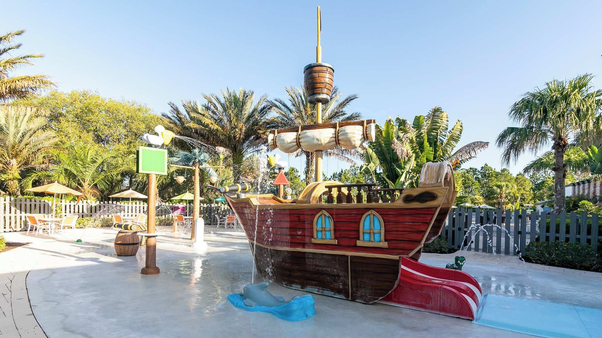 Zona de juegos temática de piratas con toboganes y fuentes de agua.