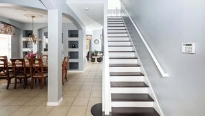 A modern interior with a staircase, dining area, and living space. - Be Our Guest at Emerald Island (Kissimmee)