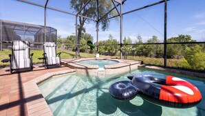 Un espace piscine équipé d’un jacuzzi, de chaises longues et de bouées gonflables.