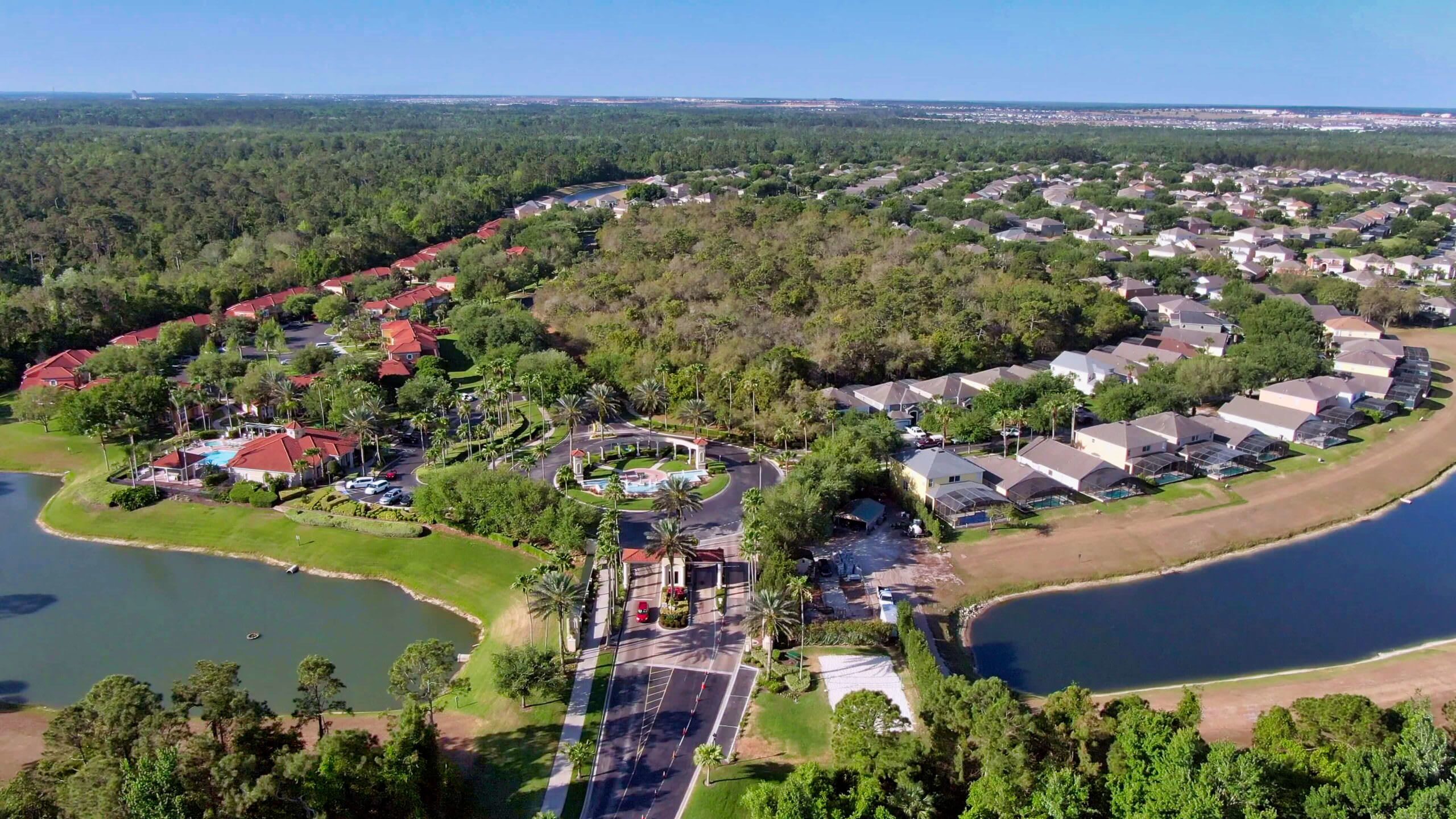 Un barrio residencial con casas, un parque central y un lago.