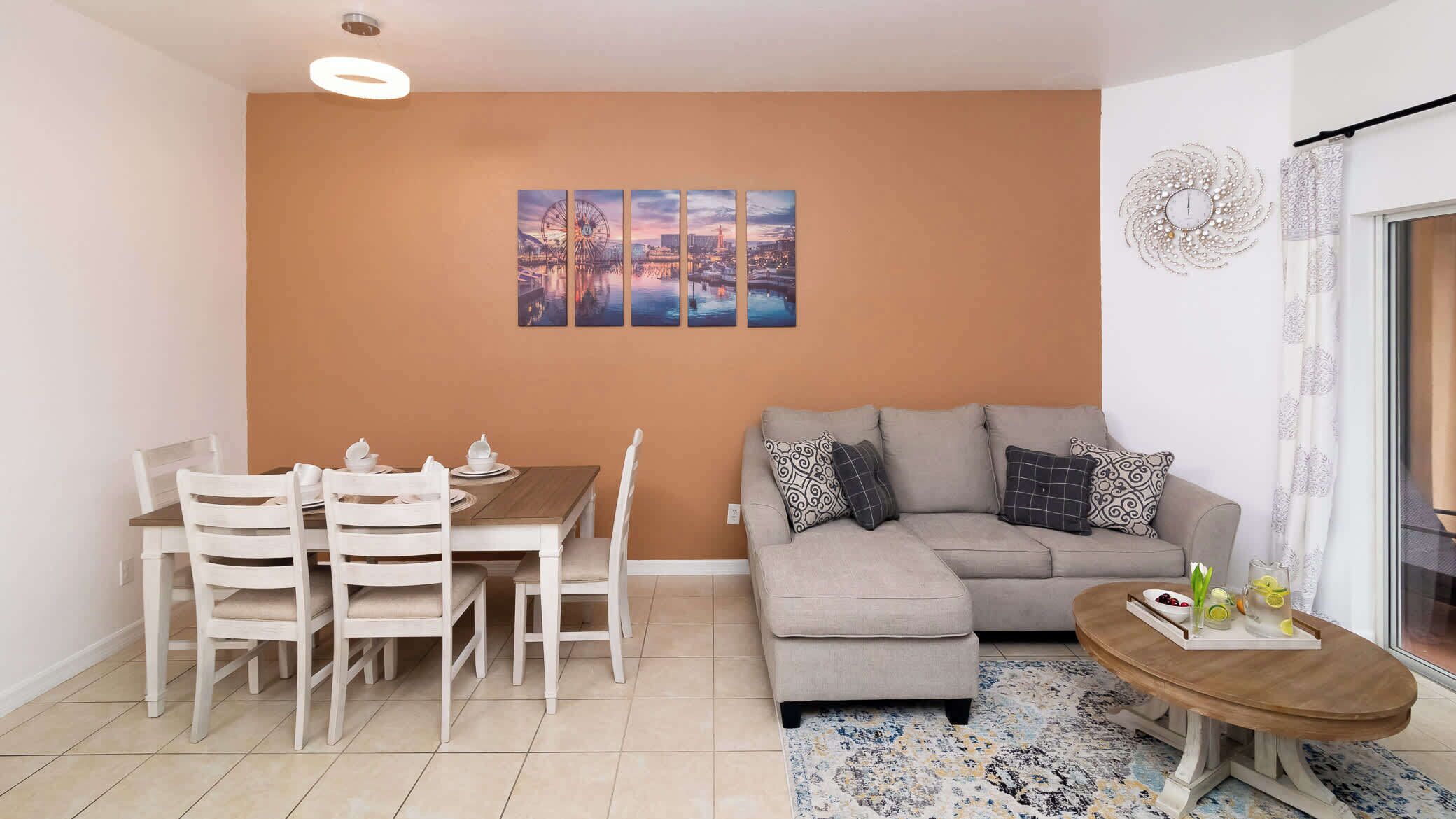 A living room with a dining table, chairs, a sofa, and a coffee table.