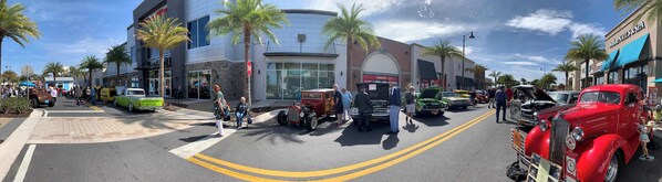 A street with vintage cars and palm trees.