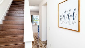 Una escalera con escalones de madera que lleva a un espacio interior luminoso.