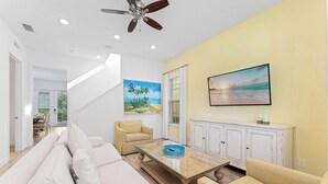 A living room with a sofa, armchairs, a coffee table, a painting, a cabinet, and a ceiling fan. - Parrot Paradise Escape for 8! (Kissimmee)