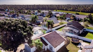 Un barrio residencial con casas que tienen paneles solares, piscinas y abundante vegetación.