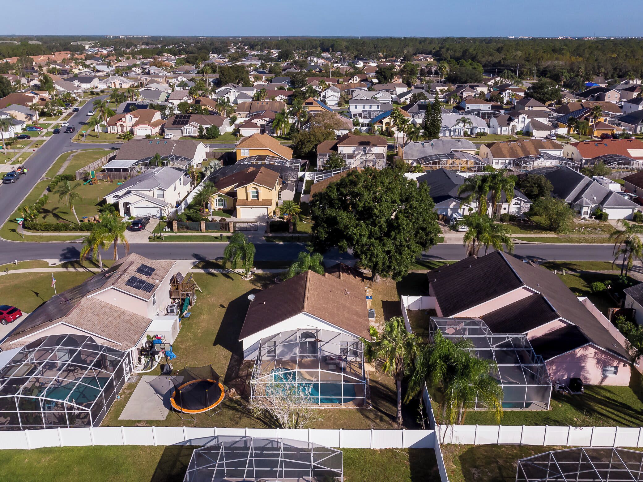 Zona residencial con casas, calles y un árbol grande.