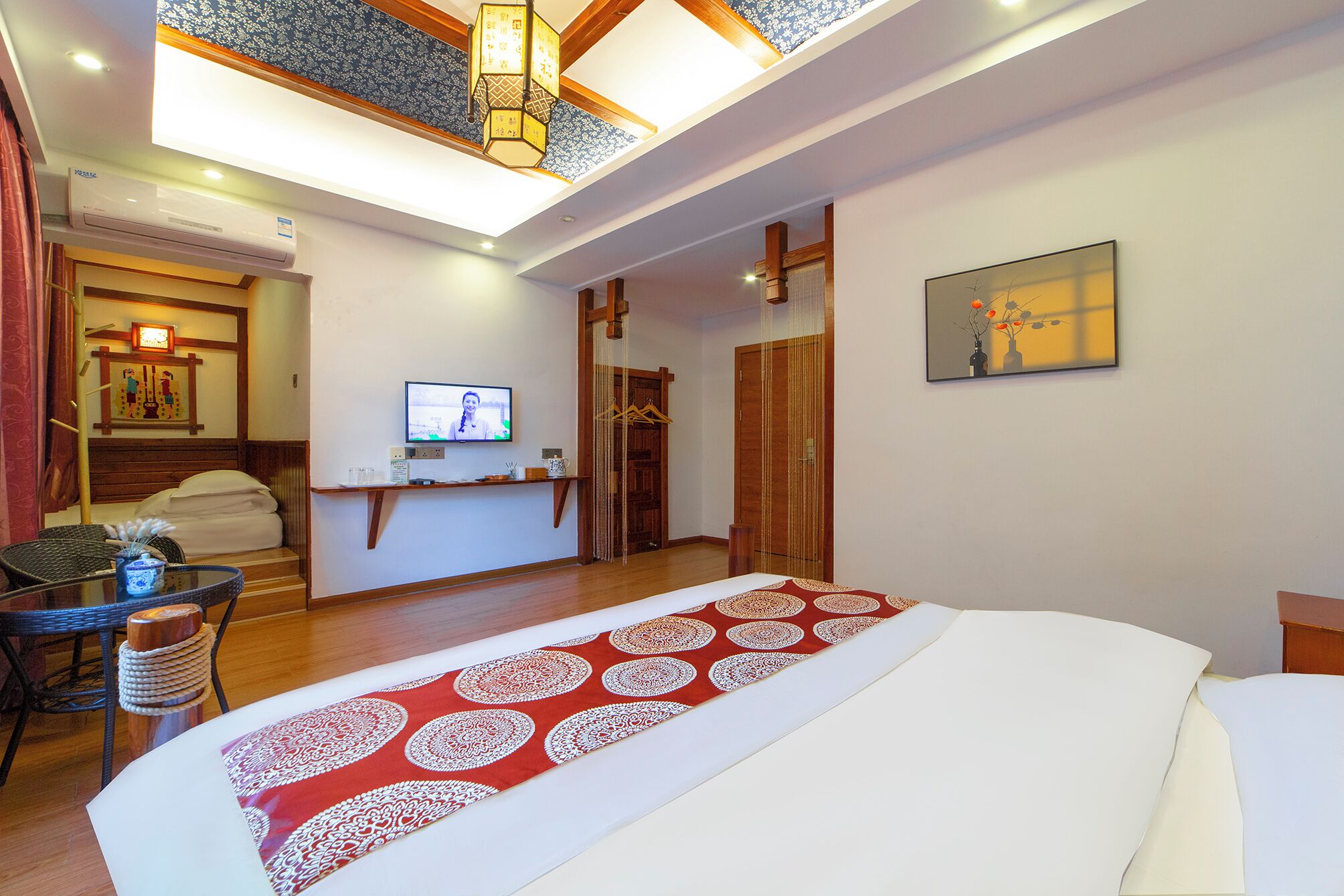 Una habitación de hotel con cama, televisión, escritorio con computadora y ventana con cortinas.
