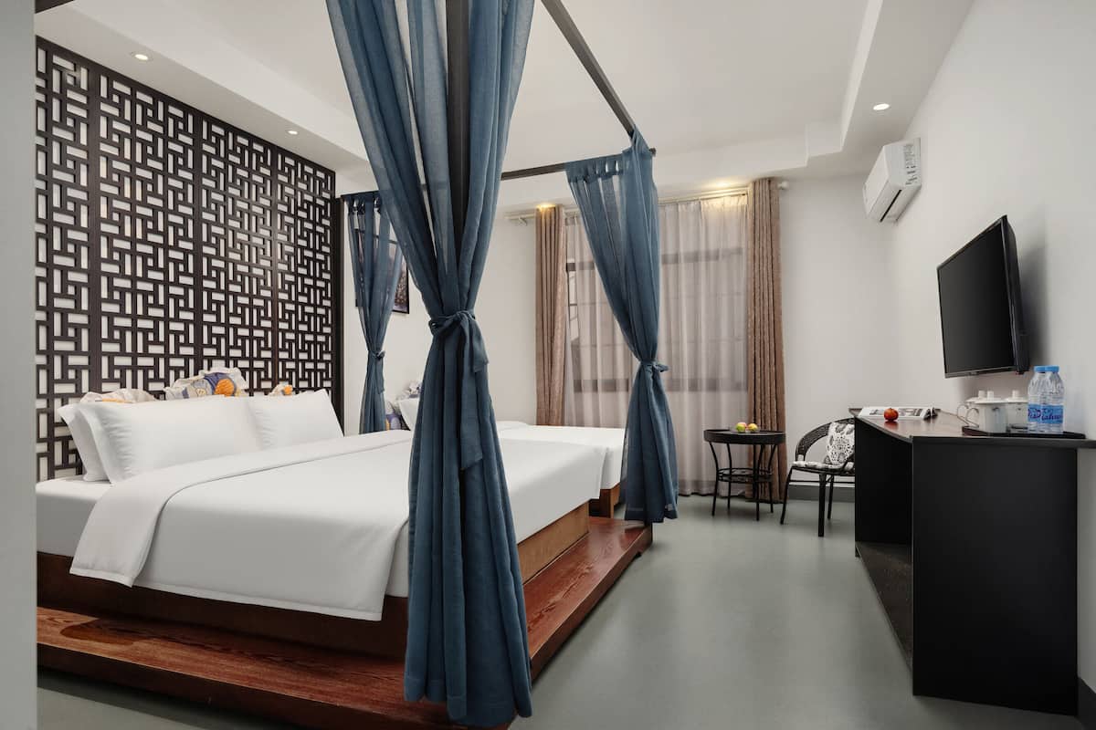 Une chambre d’hôtel équipée d’un lit, d’un bureau, d’une chaise, d’une télévision et d’un appareil de climatisation.