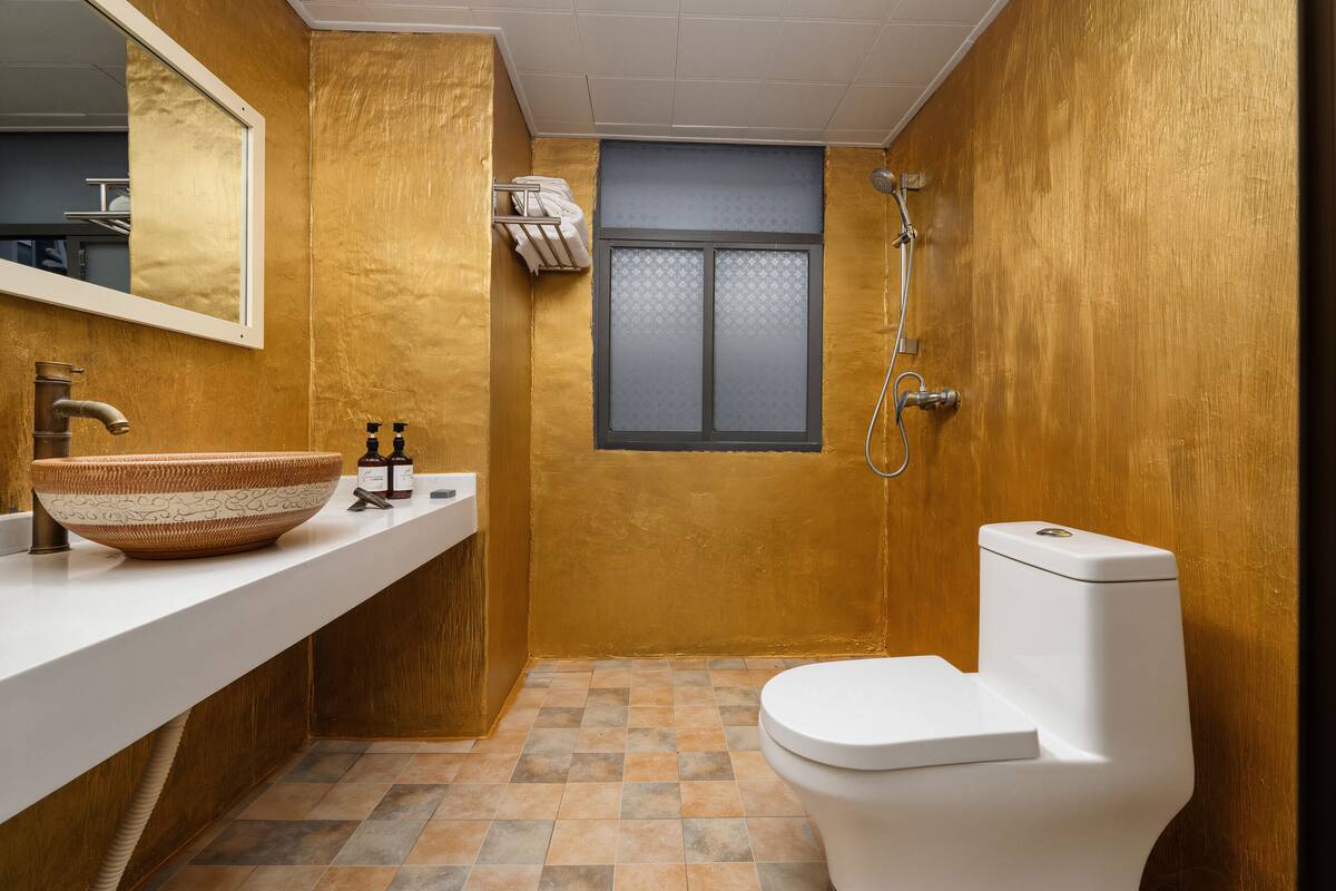 Une salle de bain avec un lavabo blanc, un grand bac, des toilettes et une douche.