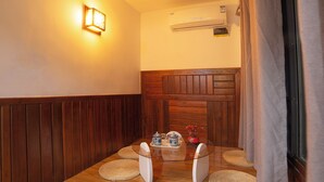 A small, cozy room with wooden paneling, a glass table with a tray of items, and a hanging light fixture. - Zhangjiajie Xinghe Qingmeng Folk-style Inn (Zhangjiajie)