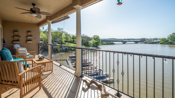 Eine überdachte Terrasse mit Holzmöbeln und Blick auf einen Fluss.