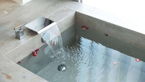 Un baño moderno con una bañera rectangular y un lavamanos pequeño.