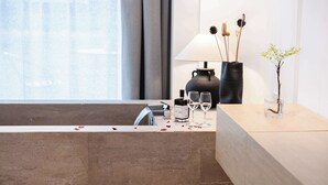 Un baño moderno con bañera, lavamanos y tocador.