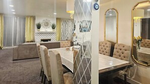 A dining area with a table set for four, surrounded by cushioned chairs. There is a decorative mirror on the wall and a chandelier above the table. - Beach • Pools • Comfort:  Private Room + Bath Prime LA Location (Los Angeles)