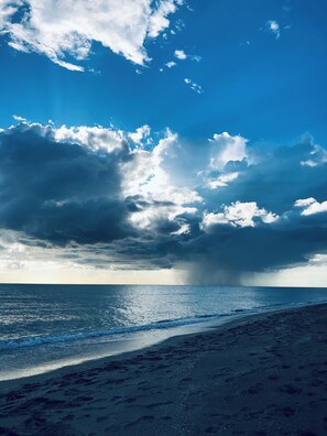 A beach with a clear sky and clouds.