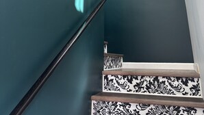 A staircase with a black and white patterned railing, leading up to a landing with a white ceiling and a vent. - Parkside Nest Apartment Near Manito Park (Spokane)