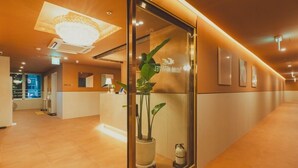 Ein Empfangsbereich mit modernem Design, ausgestattet mit einer Rezeption, einer großen Chandelier und einem Blumentopf.