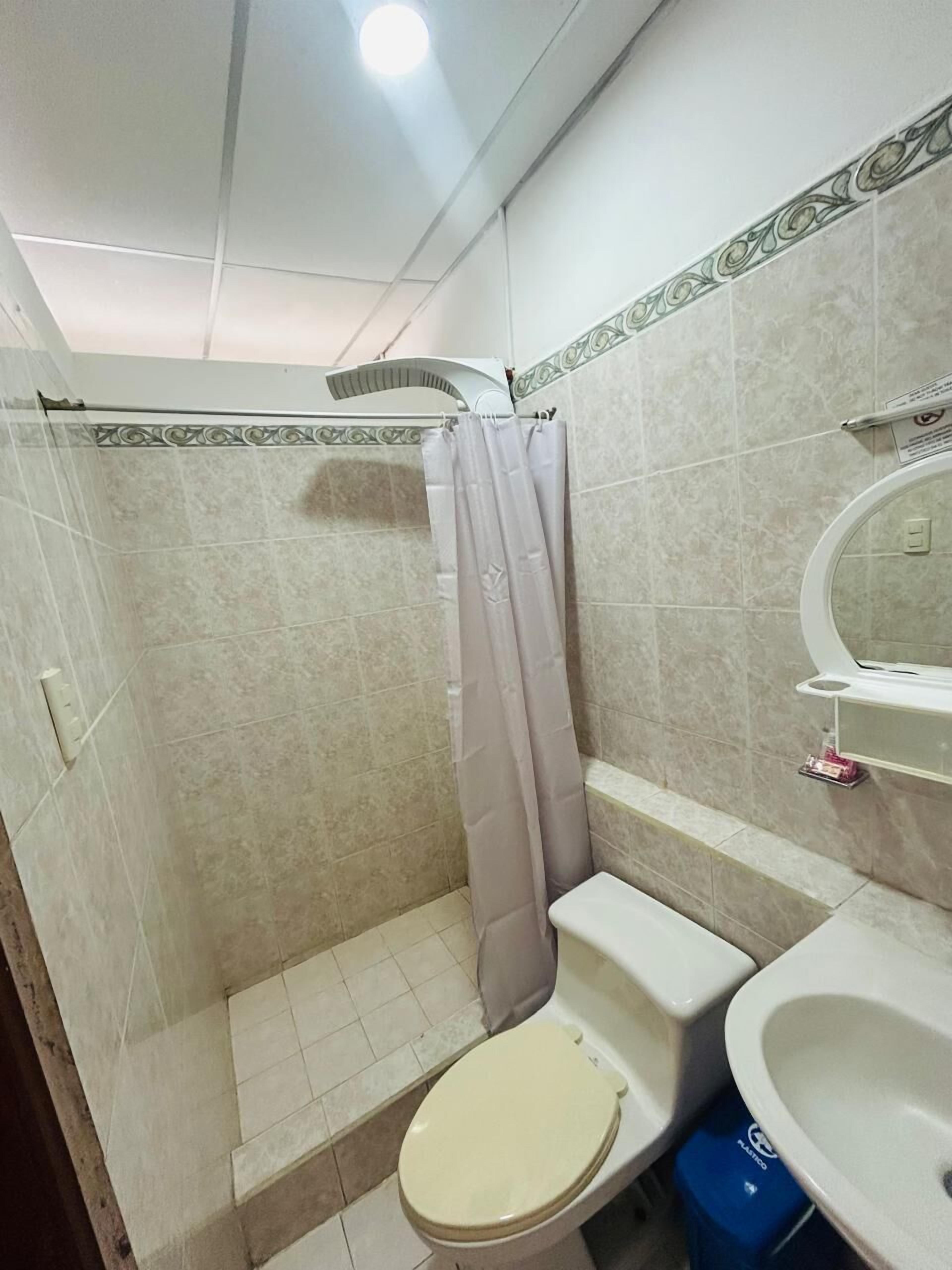 Un baño con ducha, inodoro y lavamanos.