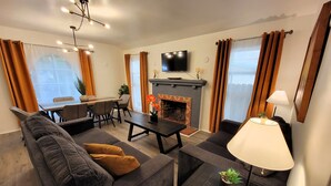 Una sala de estar moderna con un sofá, una mesa de comedor y una chimenea.