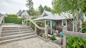 A wooden staircase leading to a house with a metal roof, surrounded by greenery and other houses in the background. - 5 min. Walk to Town & Beach, Greenbelt Views + Private Backyard (Pacific Beach)
