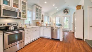 A modern kitchen with white cabinetry, stainless steel appliances, and a wooden floor. - 5 min. Walk to Town & Beach, Greenbelt Views + Private Backyard (Pacific Beach)