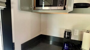 A compact kitchen with a microwave, coffee maker, and a small refrigerator. - Modern Cozy Pebble Beach Studio with Premium Amenities and WiFi (Del Monte Forest)