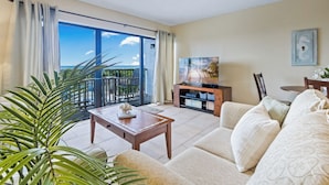 A living room with a balcony, a television, and a sofa.