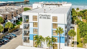 A hotel named 'Chateau By The Sea' with a view of the beach and ocean.