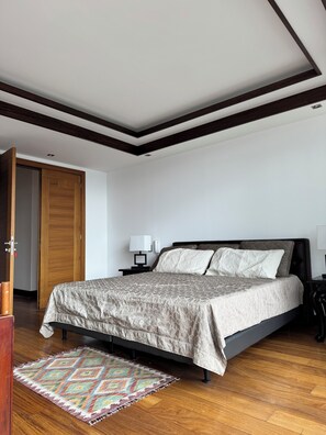 Relax in this stylish bedroom with a large bed, bedside tables, and a spacious wardrobe.