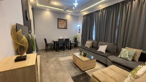 Una sala de estar moderna con sofá, mesa de centro y comedor con sillas y mesa.