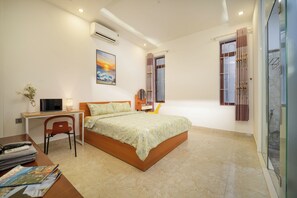 A bedroom with a bed, desk, chair, and a shower area. - Charming 4-bedroom house with AC and WiFi in enchanting Đà Nẵng (Đà Nẵng)