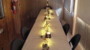 A long table with a white tablecloth, decorated with pinecones, lights, and candles. - Charming 2-bdrm cabin in Fawnskin, with Wifi & just a 5 minute walk to the lake (Fawnskin)
