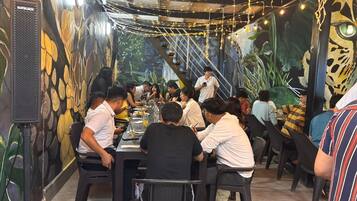 Un restaurante con un mural, luces colgantes y un altavoz.