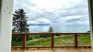 A balcony with a view of a lake and mountains. - Paradise Suites Eagles Nest Apt C (Homer)