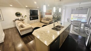 A modern kitchen with a granite countertop, stainless steel appliances, and a built-in oven. - A/C, Fenced backyard , BBQ grill, pets welcome (Edmonton)