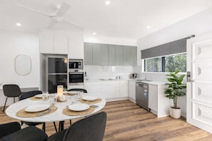 A modern kitchen with white cabinets, a built-in oven, and a dishwasher.