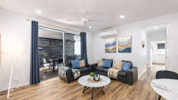 Una sala de estar moderna con un sofá modular, una mesa de centro y un comedor.