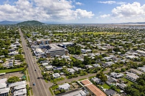 Vista aérea de una zona residencial con una avenida central, edificios y zonas verdes.