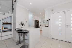 Functional kitchen with a sleek island, white cabinetry, and appliances.