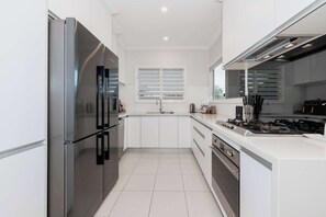 Enjoy cooking in this well-equipped kitchen with a gas stove, oven, and large refrigerator.