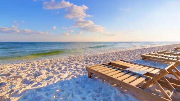 A beach with wooden lounge chairs and a clear view of the ocean. - Top Gulf Coast Perdido Key Getaway Island Vacation (Perdido Key)