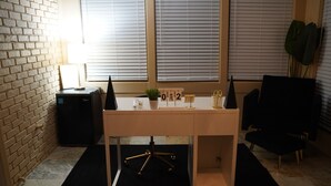 A desk with a plant, a calendar, and a pair of scissors.