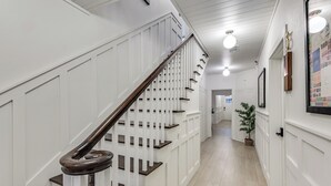Un escalier avec des panneaux blancs et des marches en bois foncé.