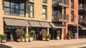A multi-story building with a brick facade, large windows, and outdoor potted plants. - Luxury Urban Hideaway (London)