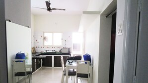 A kitchen with a window, a ceiling fan, and a dining area with chairs and a table.